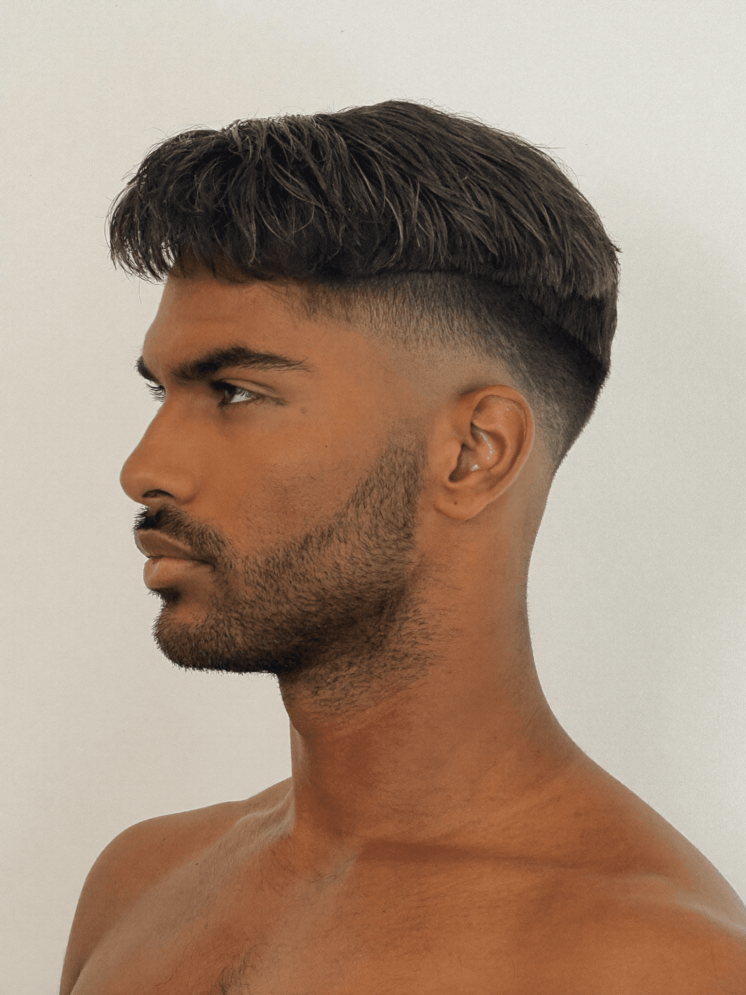 Kunde nach dem Textured Crop bei Salon Élite – präzise Fade mit gewelltem Top